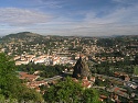 Výhled z vrcholu Rocher Corneille na město Le Puy-en-Velay přes vrchol Rocher d'Aiguilhe s kostelem St-Michel