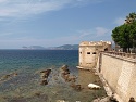 Výhled z města Alghero přes Torre San Giacomo ke Capo Caccia