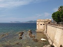 Výhled z města Alghero přes Torre San Giacomo ke Capo Caccia