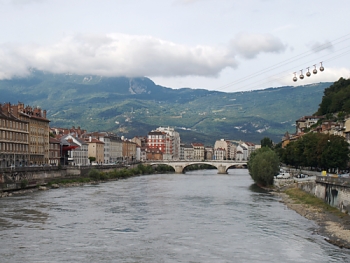 Grenoble s řekou Isère, v pozadí hřeben Vercors