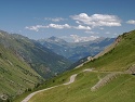 Výhled do údolí Villards ze sedla Col du Glandon, zasněžená hora v dáli je Mont Blanc